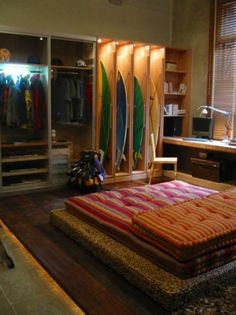 a bedroom with surfboards on the wall and closets full of clothes in it