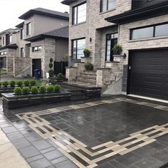 an empty driveway in front of some houses with plants on the side and steps leading up to them