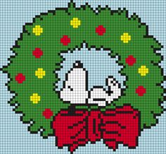 a cross stitch christmas ornament with a dog in a wreath on it's front