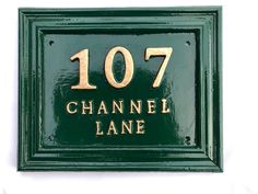 a green and gold plaque with the name channel lane written on it's side