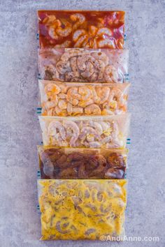 five bags filled with different types of food sitting on top of each other in front of a wall