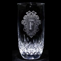 a glass with the letter i on it and an ornate design in the middle, against a black background