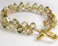 Gorgeous yellow champagne and subtle peridot green Swarovski crystals are accented with gold Swarovski rhinestone crowns to create a stunning tennis style bracelet. Perfect modern chic accessory for a formal wedding or soiree. Handmade, sparkly and yet understated. Bracelet Details: - Bracelet length is 7.5 inches long (19.05 cm) - Bracelet is .5 inches wide (1.27 cm) - Finished with a different heart shaped toggle clasp (not shown). - A tennis style bracelet is designed to fit flat against your Formal Necklaces, Green Wedding Jewelry, Purple Crystal Bracelet, Yellow Champagne, Gold Tennis Bracelet, Jewellery Board, Crystal Wedding Jewelry, Tennis Style, Wedding Bridesmaid Jewelry