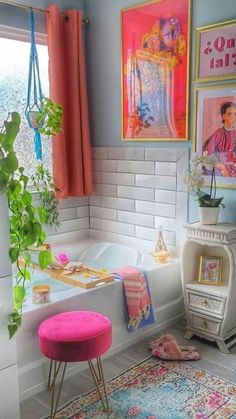 a bathroom with pictures on the wall and a pink stool in front of a bathtub