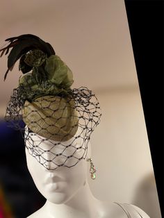 This OTO-08 fascinator is expertly crafted with an olive sinamay base, complemented by delicate feathers and a veil. Its intricate design exudes elegance and enhances any formal attire, making it a must-have for any special occasion. Elevate your outfit with this stunning accessory. Elegant Feathered Headpiece For Vintage Events, Elegant Party Fascinator With Feather Trim, Elegant Feathered Fascinator For Vintage Events, Elegant Feather Fascinator For Vintage Events, Elegant Ostrich Feather Fascinator For Wedding, Elegant Evening Fascinator With Feather Trim, Elegant Feathered Fascinator For Formal Occasions, Elegant Feather Fascinator For Events, Elegant Fascinator With Feathers For Events