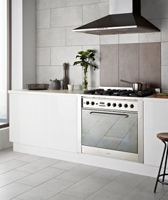 a stove top oven sitting inside of a kitchen next to a window and counter tops