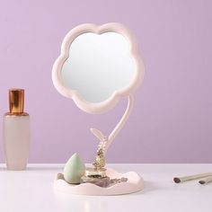 a white vanity mirror sitting on top of a table next to a bottle of makeup