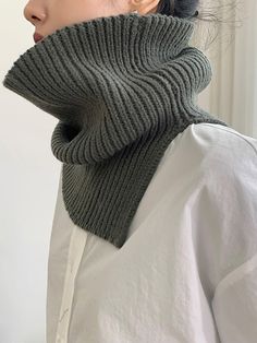 a woman wearing a gray knitted neck scarf