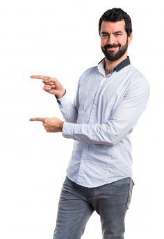 a man with a beard is pointing to something on his left hand and smiling at the camera