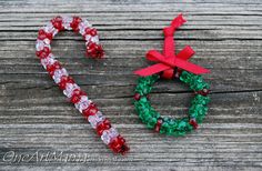 two candy canes sitting next to each other on a wooden surface with the word christmas spelled out