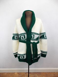 "Vintage 1970's chunky knit cardigan sweater in green and white acrylic yarn. Very good vintage condition. No tags or labels. Please refer to the following measurements when considering fit.  Length approximately 27\" Chest 38\" Sleeves approximately 24\" *Please note that vintage clothing and contemporary sizes can vary greatly. We take measurements of listed garments by laying the garment flat and then doubling the measurement. When considering whether a garment would fit, we suggest taking a similar garment from your own wardrobe and measure it lying flat as we do. Then compare the measurements." Vintage Green Knit Outerwear, White Retro Winter Cardigan, Retro Green Winter Sweater, Green Retro Winter Sweater, Retro White Knit Cardigan, White Knit Retro Cardigan, Vintage Green Knit Cardigan, Vintage Green Knit Sweater, Retro Green Knitted Sweater