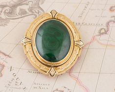 This incredible double sided brooch has a pin to allow either the green malachite stone to show or the gray blue agate. This versital pin has a rich dark green cabochon cut bezel set malachite on one side and a misty gray cabochon cut agate on the other side. The pin spins smoothly to switch to the other side. This brooch has some dents on the back from its age, which are pictured above. I love the carefully crafted metal work and milgrain on the metal frame.  Normal Price: $1,295.00 Metal Type: Luxury Green Pendant Brooch, Green Gemstone Pendant Brooches, Antique Green Gemstone Brooches, Oval Green Brooch Jewelry, Green Oval Brooches For Formal Occasions, Antique Green Pendant Brooch, Misty Grey, Green Malachite, Malachite Stone