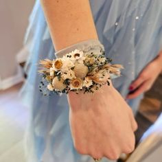 a woman wearing a bracelet with flowers on it's wrist and an armband