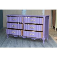 a purple dresser sitting on top of a wooden floor