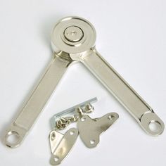 a pair of metal keys and a keyring on a white surface