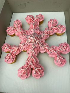 a box filled with cupcakes covered in pink frosting