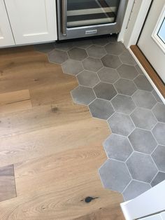 a kitchen floor with hexagonal tiles on the floor and an oven in the background