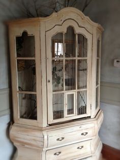 an old white china cabinet with glass doors