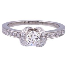 A 1999 Tiffany & Co Ribbon Diamond ring featuring a .42 ct Center H VS1 diamond.  The diamond is set in Tiffany's Ribbon style ring, which is adorned with an additional 29 diamonds , E-G Color , VS clarity, weighing a total of .30cts.  Included with the ring is the original Tiffany and Co. Certificate and Tiffany evaluation report.  This ring was recently polished, and restored to brand new condition.  Fully hallmarked with logo, serial numbers and metal content.  Currently a size 6.25 and can be re-sized.   Condition Report Excellent.   Recently polished, and in brand new condition.  See Video for details.  The metal shows an excellent shine, with no scratches or dents. The hallmark stamps are in perfect shape.  The paperwork includes original certificate , retail replacement documents fr Tiffany Melody Ring, Tifanny And Co Rings, Tiffany Engagement Ring, Ribbon Style, Vs1 Diamond, Tiffany And Co, White Satin, Jewelry Rings Engagement, Tiffany & Co.