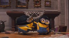 two minions from despicable me standing next to each other in front of a fireplace