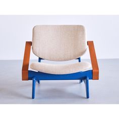 an upholstered chair with wooden legs and blue frame