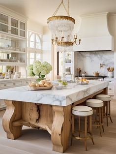 a large kitchen island with marble counter tops and stools in front of an oven