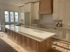 a large kitchen with white cabinets and marble counter tops in the process of remodeling