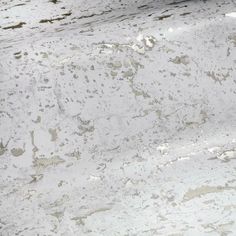 a white marble counter top with brown spots on it