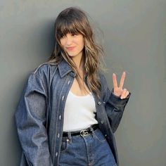 a young woman is posing for the camera with her peace sign in front of her