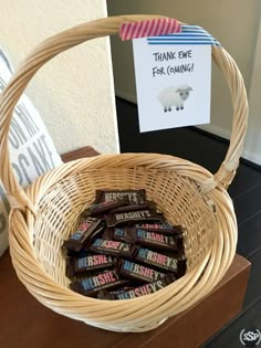 a wicker basket filled with chocolates sitting on top of a table next to a sign