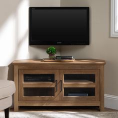 a flat screen tv sitting on top of a wooden cabinet