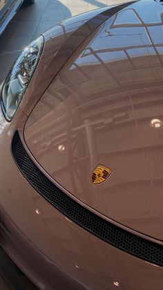 the front end of a brown sports car