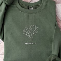 a green sweatshirt with the word monstera printed on it