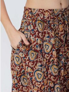 Our Venessa printed skirt, made from soft cotton fabric, features an A-line silhouette perfect for most body types. This regular-fit Kalamkari skirt with an elasticated waistband is a great option for all-day wear, especially during the summer months. Kalamkari is a highly popular form of block-printed cotton textile produced with the help of kalam, meaning pen. During the process, a sharp-pointed pierced bamboo regulates the flow of color/organic dye on the fabric. This maroon-colored skirt comes with one pocket, making it an ideal casual-wear wardrobe staple. To add some extra fun, you can pair it with a monotone shirt or top and elevate your style effortlessly. Material: Cotton Style/Print: Kalamkari Waist: 30” Length: 39” Fit: A-line Occasion: Casual Color: Maroon Lining: No Multicolor Cotton Knee-length Skirt, Multicolor Knee-length Cotton Skirt, Cotton Floral Print Knee-length Skirt, Knee-length Cotton Skirt With Floral Print, Brown Cotton Knee-length Skirt, Brown Cotton Flared Skirt, Casual Cotton Patterned Skirt, Relaxed Fit Brown Cotton Skirt, Brown Cotton Gathered Skirt Bottoms