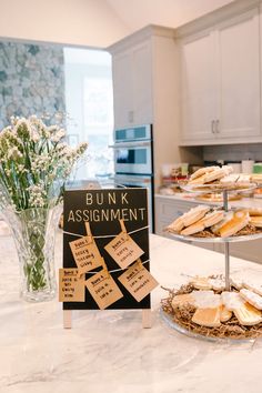 a bunch of food that is sitting on a kitchen counter with a sign in front of it