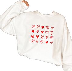 White Long Sleeve Tops With Heart Print, White Long Sleeve Top With Heart Print, Winter White Tops With Heart Graphic, White Tops With Heart Graphic For Winter, Long Sleeve T-shirt With Heart Graphic For Gift, Casual Heart Graphic Sweatshirt Gift, Heart Graphic Long Sleeve Top As Gift, Long Sleeve Tops With Heart Graphic As Gift, Long Sleeve Tops With Heart Graphic For Gift