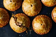 several pies are arranged on a black surface