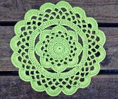 a crocheted doily is sitting on a wooden surface