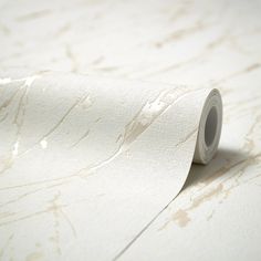 a roll of white paper sitting on top of a table next to a wallpaper