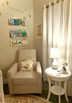 a white chair sitting next to a table with a lamp on top of it