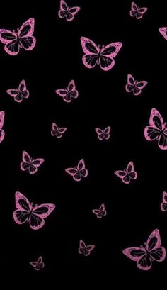 many pink butterflies are flying in the dark