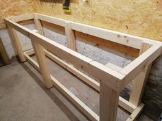 a wooden bench being built in a room with plywood boards on the walls and floor