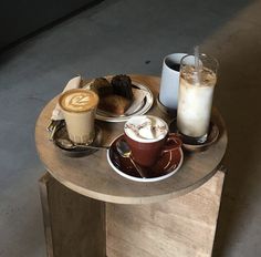 two cups of coffee and some pastries on a table