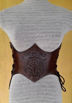 It is Handmade leather corset with Tooled beautiful designs. Handmade and hand dyed belt with high quality leather. It is adjustable with lace.  MEASUREMENTS: S/M : 66 cm - 74 cm / 26" in - 29"in M / L: 75 cm-85 cm / 29.5 "in - 33.5" in L / XL: 85 cm-95  cm / 33.5 "in - 37.4" in DETAILS: ► 100% handmade ► 100% genuine leather ► Made on your measurements ► Unique design ► Battle ready ► LARP standard ► Worldwide delivery NOTE: This item can be personalized on request (contact us) We remind our cu Gothic Corset With Belt For Cosplay, Fantasy Overbust Corset Belt For Larp, Steampunk Leather Corset For Cosplay, Fantasy Underbust Corset Belt For Larp, Medieval Style Corset Belt For Festivals, Medieval Corset Belt For Festivals, Medieval Underbust Corset Belt For Cosplay, Medieval Overbust Corset Belt For Cosplay, Gothic Leather Corset For Cosplay