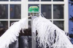 a green and white hat sitting on top of a metal pole next to a window