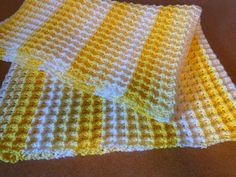 yellow and white crocheted cloths laying on top of each other