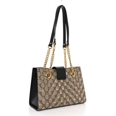 This is an authentic GUCCI GG Supreme Monogram Bees Small Padlock Tote in Beige, Oro, and Black. This chic shoulder bag is crafted of Gucci GG monogram coated canvas with a gold bee print and black leather trim. The handbag features gold chain handles with leather shoulder pads and a crossover flap with a gold padlock. The top is open to a beige suede interior with patch pockets. Gg Monogram, Gold Bee, Bee Print, Leather Trim, Leather Trims, Shoulder Pads, Gold Chain, Crossover, Patch Pocket