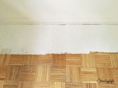 an empty room with hard wood flooring and white paint on the wall above it