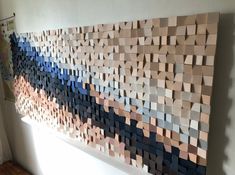 a large piece of art made out of wooden blocks on the wall next to a window