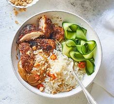 a bowl filled with rice, meat and veggies on top of a table